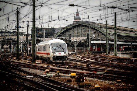 A train is going down train tracks in a train station.